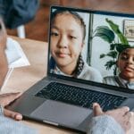 Nauczyciel prowadzi zdalną lekcję online z grupą uczniów na laptopie