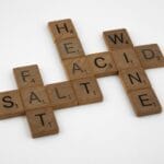 Drewniane literki ułożone w krzyżówkę z angielskimi słowami salt fat wine