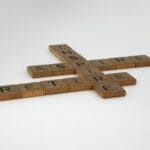 Drewniane płytki Scrabble z ułożonymi słowami na białym tle