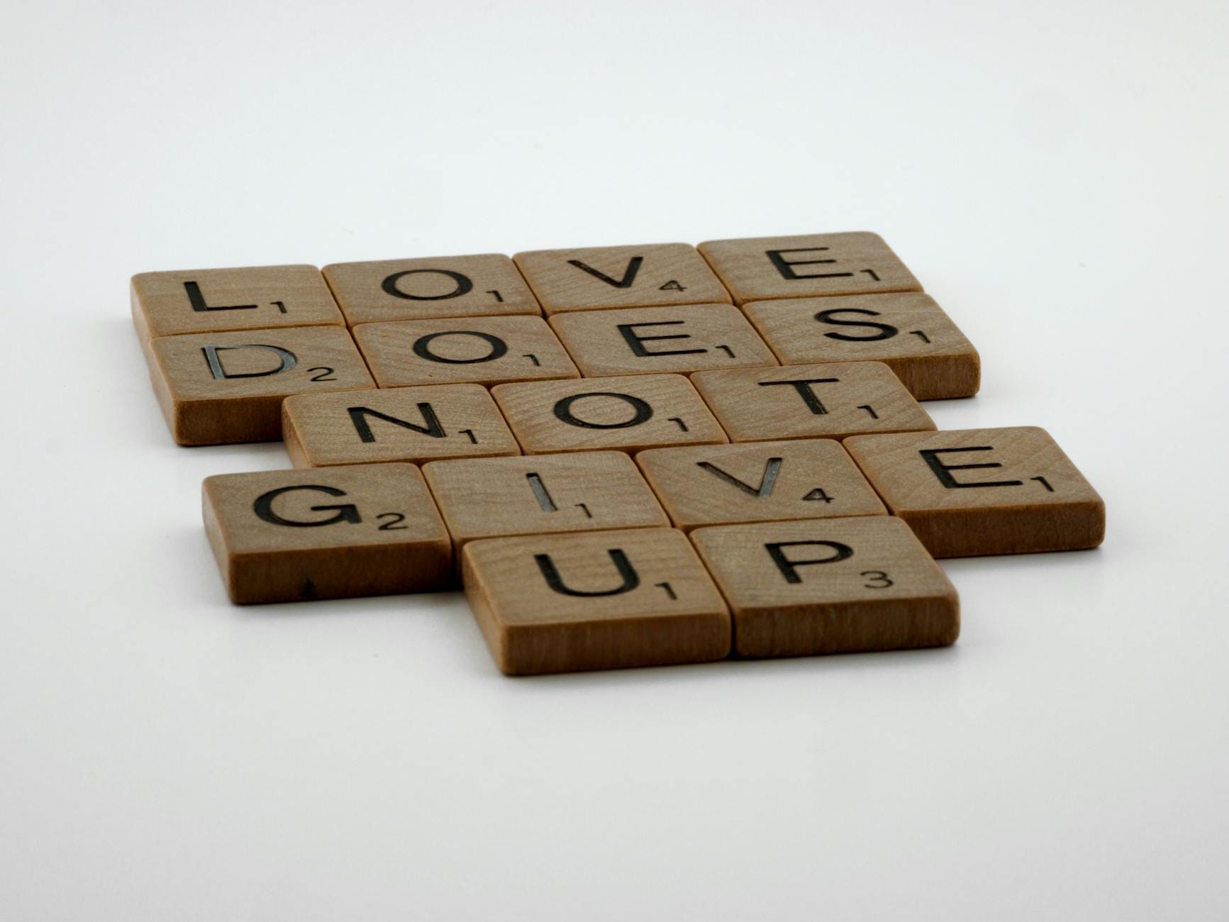 Dlaczego „NIL”, „EON” i „ER” wracają w krzyżówkach? Kafelki Scrabble układające się w hasło Love does not give up