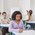 Studenci rozwiązujący test w sali, skupieni na aktywnej powtórce