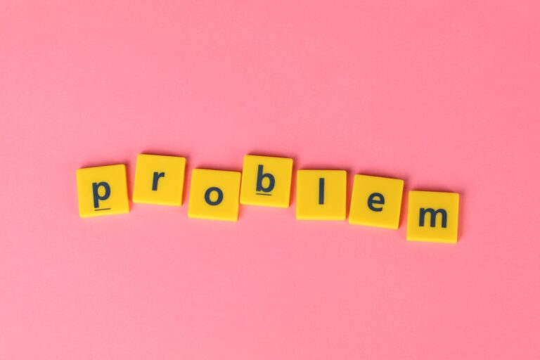 Żółte litery układające słowo problem na różowym tle